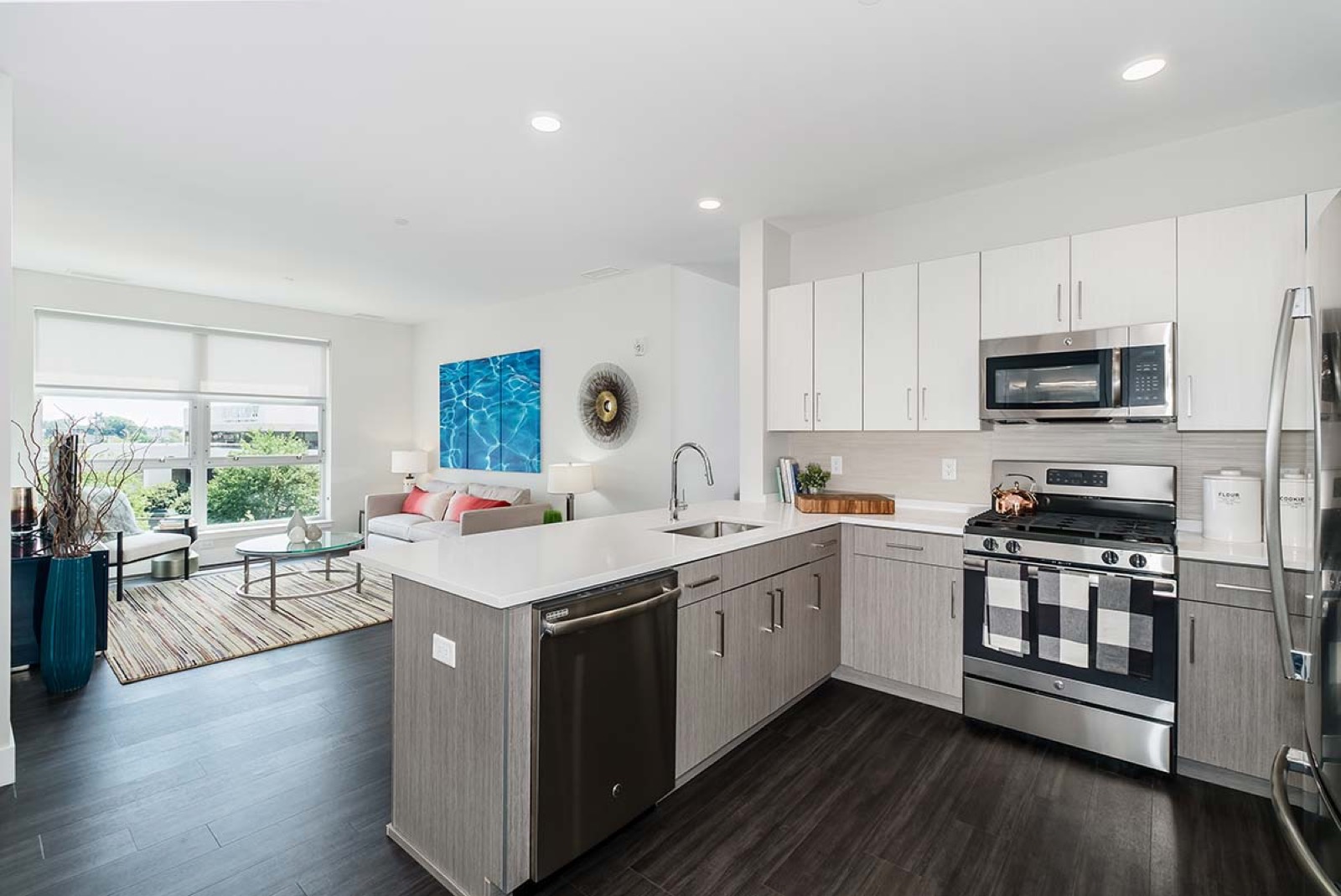 Kitchen with quartz peninsula, gas range and stainless appliances
