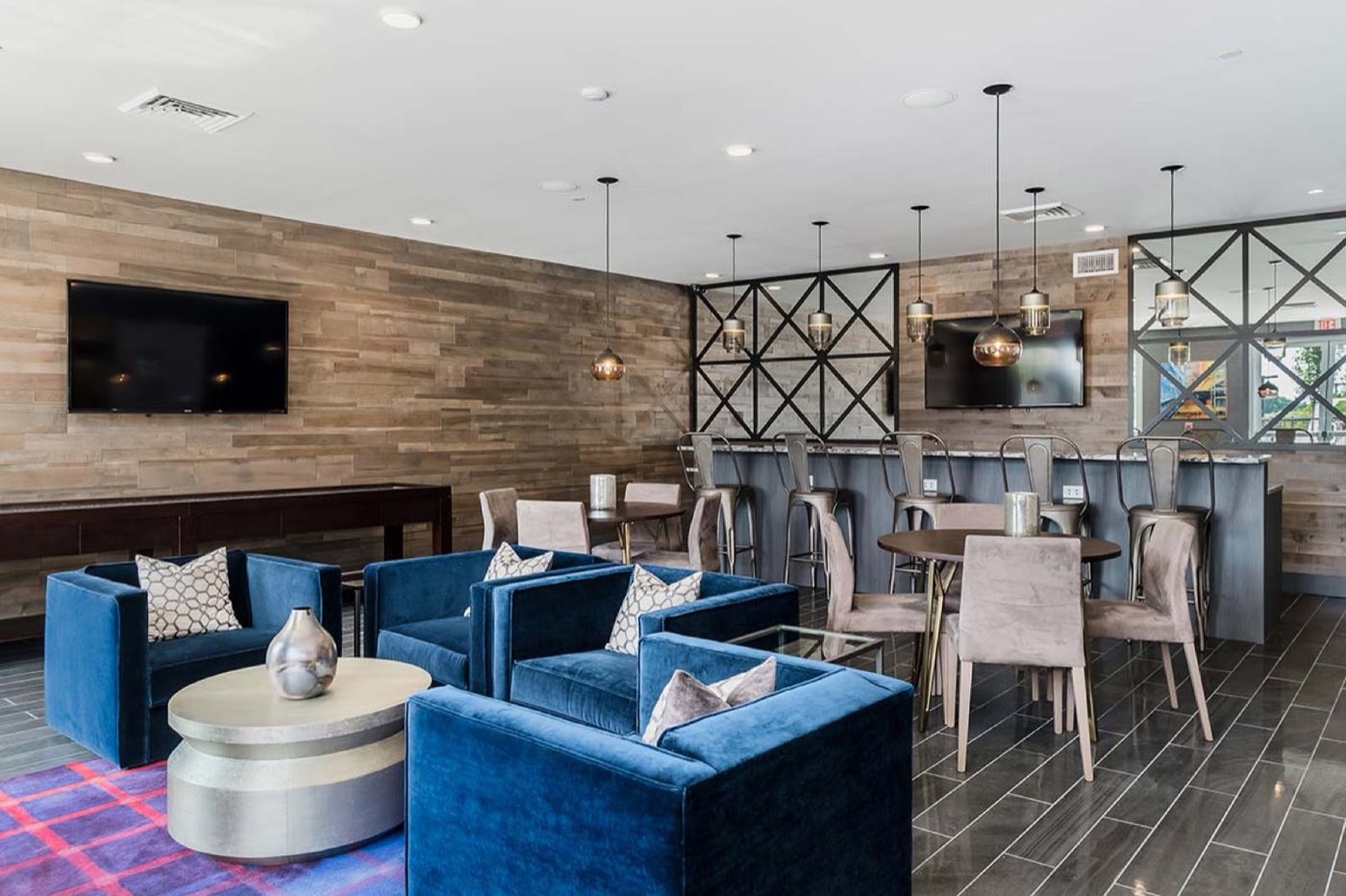 The resident lounge, with velvet armchairs, a timber wall and a bar counter